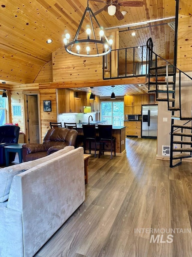 living room featuring wood walls, wood ceiling, high vaulted ceiling, and stairs