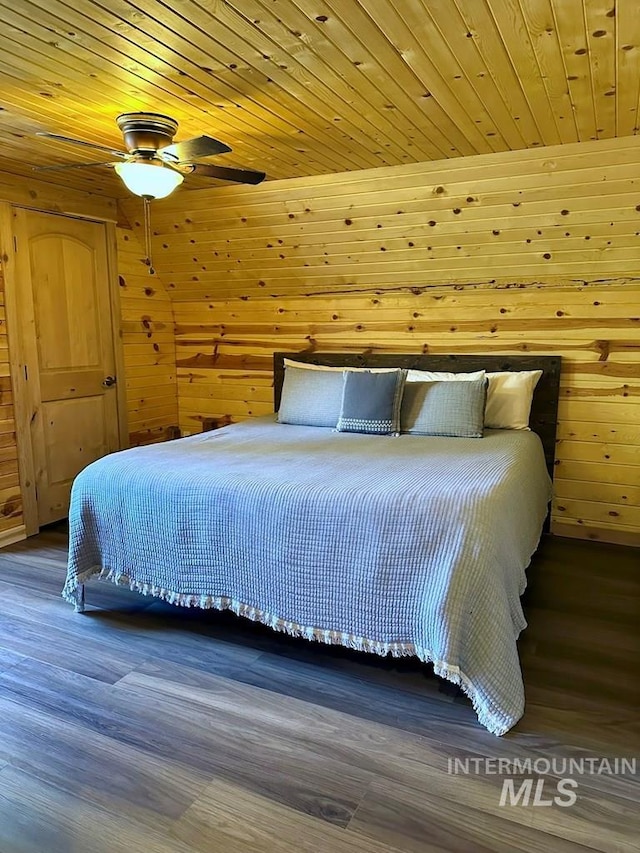 bedroom with wooden ceiling, wood walls, and wood finished floors