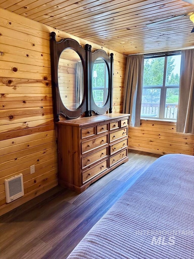 bedroom with wood walls, wooden ceiling, and dark wood-type flooring
