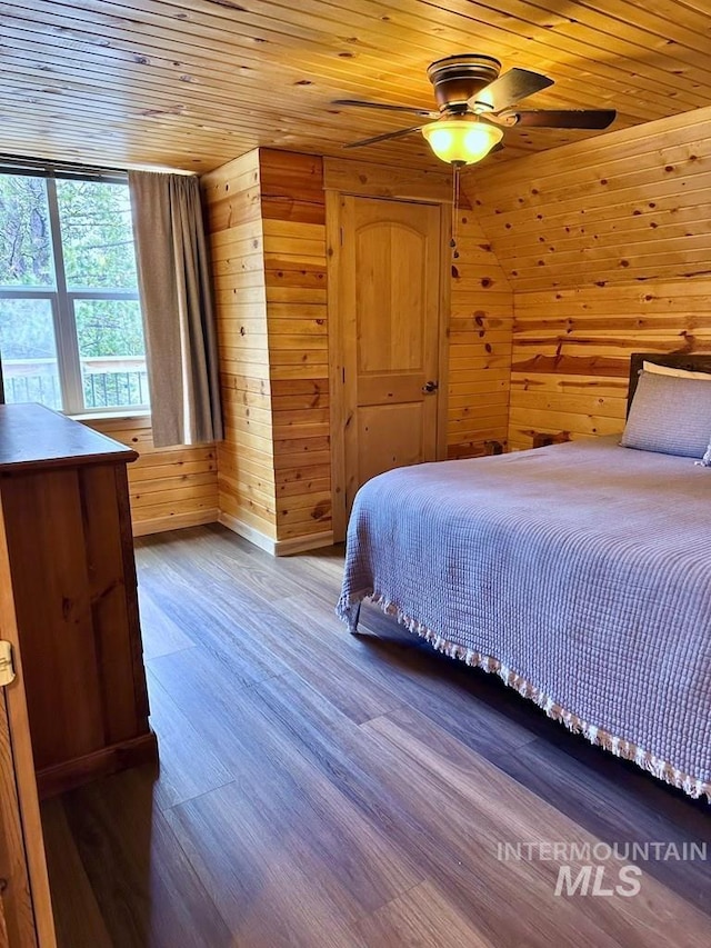 bedroom featuring wood ceiling, wood walls, and wood finished floors