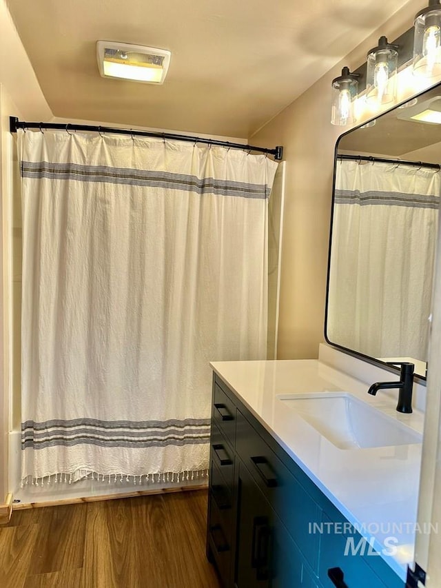 full bathroom with curtained shower, visible vents, wood finished floors, and vanity