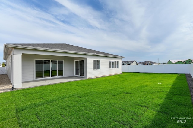 back of house with a fenced backyard, a yard, and a patio