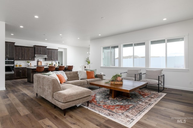 living area featuring plenty of natural light, recessed lighting, and dark wood-style flooring
