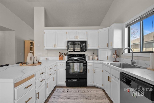 kitchen with black appliances, white cabinets, a peninsula, and a sink