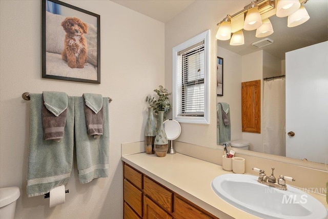 bathroom featuring visible vents, curtained shower, toilet, and vanity