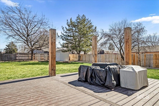 deck featuring a lawn, an outdoor structure, and a fenced backyard