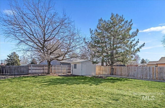 view of yard with an outbuilding, a fenced backyard, and a storage shed