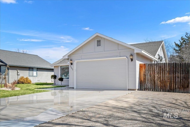 ranch-style house with a front lawn, an attached garage, driveway, and fence