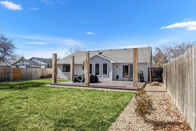 rear view of property featuring a patio area, a lawn, and a fenced backyard