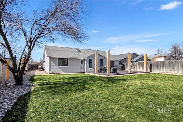 back of property with a yard, a patio, and a fenced backyard