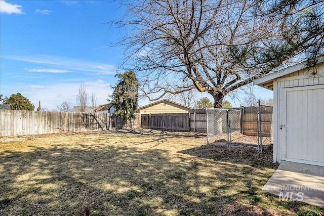 view of yard featuring an outbuilding, a fenced backyard, and a shed