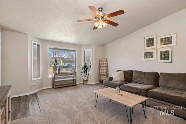 living room with light colored carpet, baseboards, a textured ceiling, and vaulted ceiling