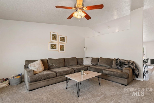 living area featuring a ceiling fan, vaulted ceiling, light colored carpet, and a textured ceiling