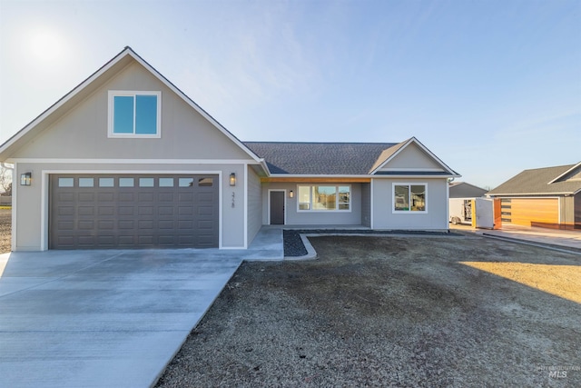 view of front of home with a shingled roof and concrete driveway