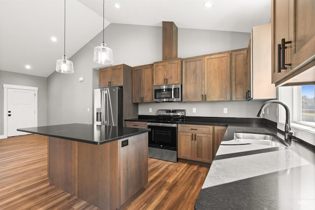 kitchen featuring dark wood-style flooring, decorative light fixtures, a center island, stainless steel appliances, and a sink