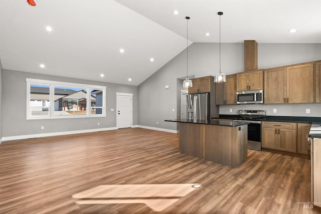 kitchen with open floor plan, stainless steel appliances, dark countertops, and a center island