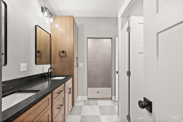 bathroom with double vanity, a stall shower, a sink, and tile patterned floors