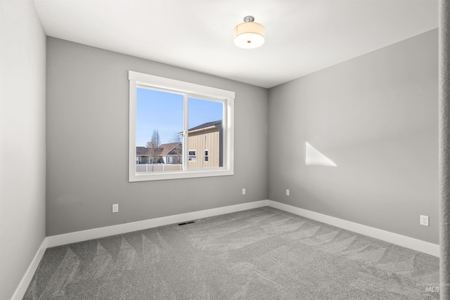 carpeted empty room with visible vents and baseboards