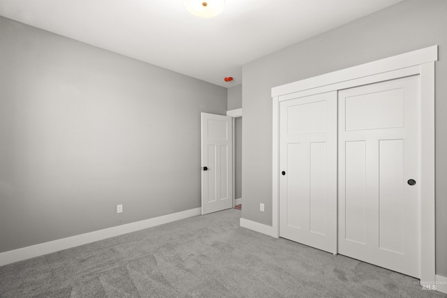 unfurnished bedroom featuring a closet, carpet, and baseboards