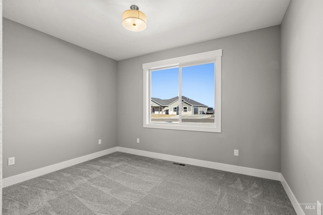 carpeted empty room with visible vents and baseboards