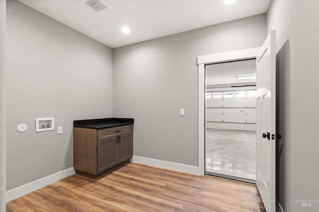 washroom with laundry area, washer hookup, visible vents, baseboards, and light wood finished floors