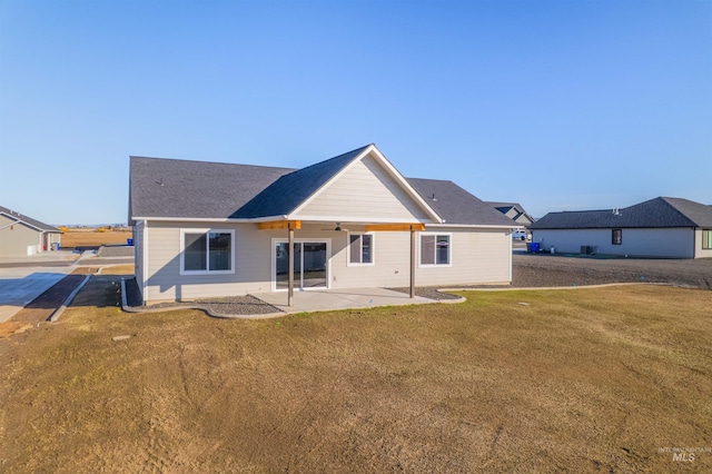 rear view of house featuring a patio area, ceiling fan, and a lawn