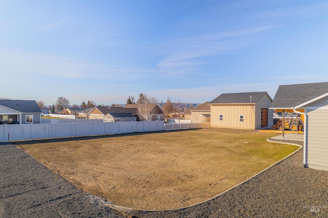 view of yard with an outbuilding, fence private yard, and a residential view