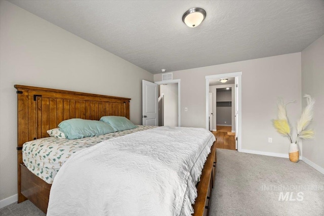 bedroom with carpet floors and a textured ceiling