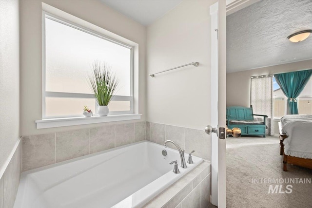 bathroom featuring a relaxing tiled tub and a textured ceiling