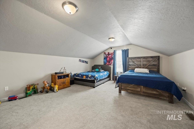 bedroom featuring carpet flooring, vaulted ceiling, and a textured ceiling