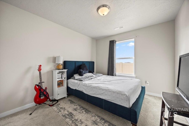 bedroom with carpet floors and a textured ceiling