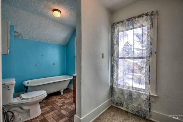 bathroom featuring a textured ceiling, toilet, a bathtub, and lofted ceiling