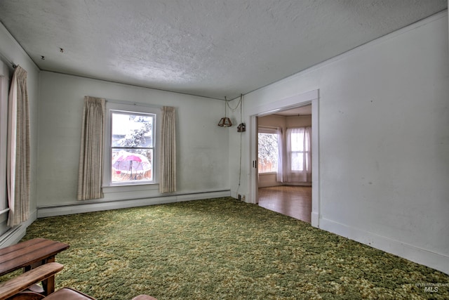 unfurnished room featuring a textured ceiling, carpet floors, baseboard heating, and a healthy amount of sunlight