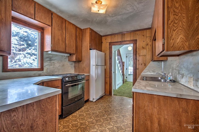 kitchen featuring black range with electric cooktop, white refrigerator, and sink