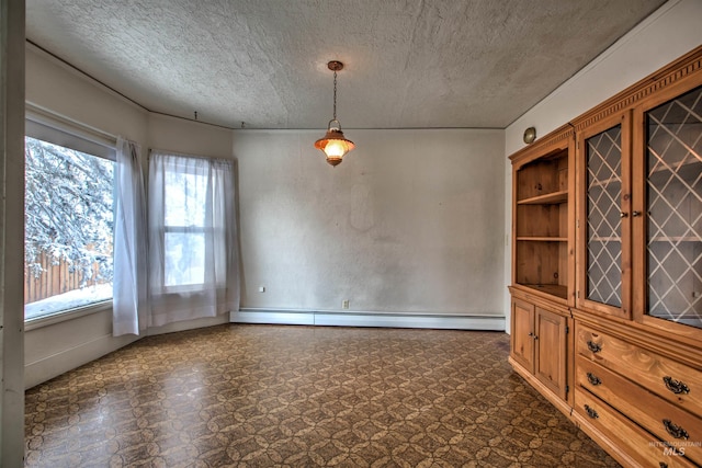 empty room featuring a textured ceiling and a baseboard heating unit