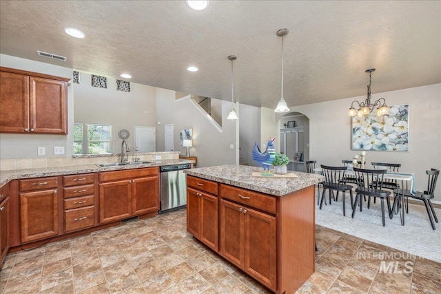 4665 N Beaham Ave, Meridian, ID 83646 - kitchen featuring stainless steel dishwasher, a sink, a textured ceiling, decorative light fixtures, and brown cabinetry