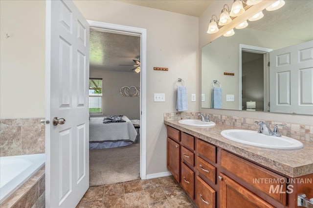 4665 N Beaham Ave, Meridian, ID 83646 - full bathroom featuring double vanity, ensuite bathroom, tiled tub, ceiling fan, and baseboards