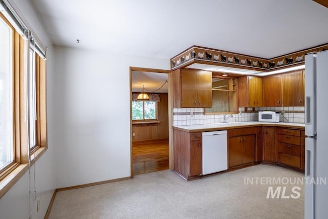 116 N Cleveland, Moscow, ID 83843 - kitchen featuring white appliances, brown cabinetry, decorative backsplash, light colored carpet, and tile countertops