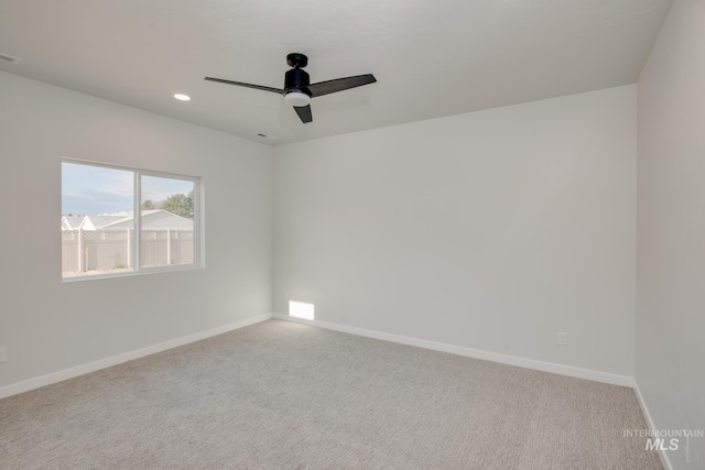 spare room with light carpet and ceiling fan