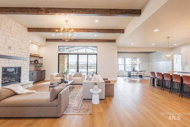 3426 N Hardwick Ave, Eagle, ID 83616 - living room with a chandelier, beamed ceiling, light wood-style floors, a stone fireplace, and recessed lighting