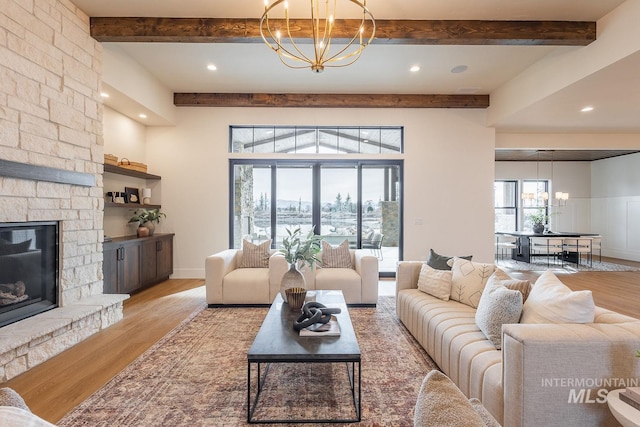 3426 N Hardwick Ave, Eagle, ID 83616 - living area with a chandelier, light wood-type flooring, beam ceiling, a stone fireplace, and recessed lighting