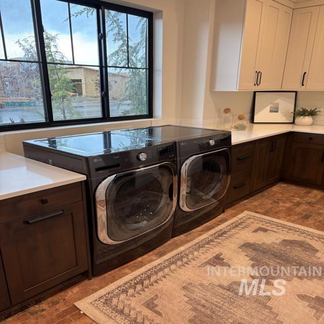 3426 N Hardwick Ave, Eagle, ID 83616 - laundry area with cabinet space, washing machine and dryer, and brick patterned floors