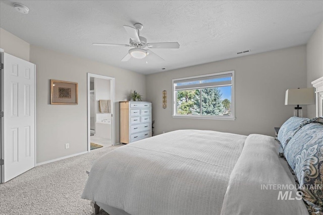 carpeted bedroom with visible vents, a textured ceiling, baseboards, and a ceiling fan