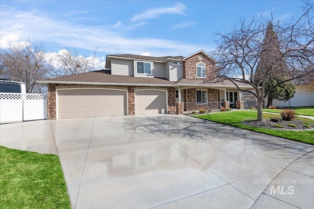 view of front facade featuring a front lawn, stone siding, fence, concrete driveway, and an attached garage