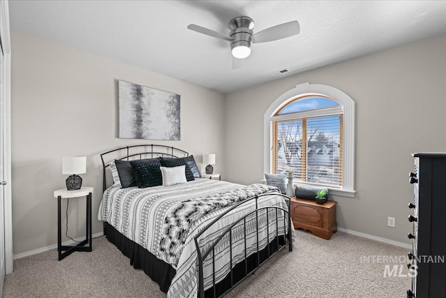 carpeted bedroom with baseboards, visible vents, and ceiling fan