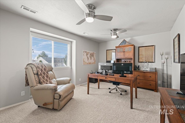 home office featuring light carpet, visible vents, a textured ceiling, and ceiling fan