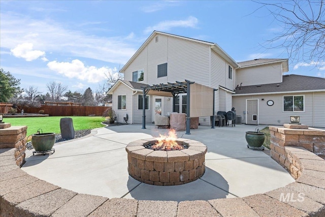 back of property with a yard, a patio area, a pergola, and an outdoor fire pit