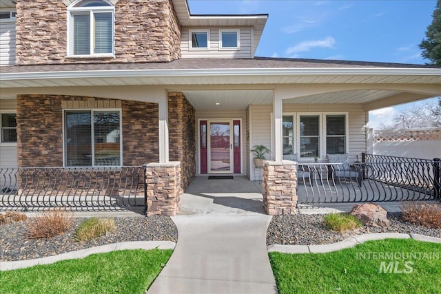 doorway to property with stone siding and a porch