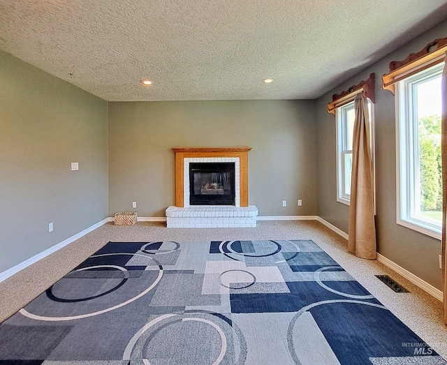 living area featuring recessed lighting, visible vents, carpet, baseboards, and a textured ceiling