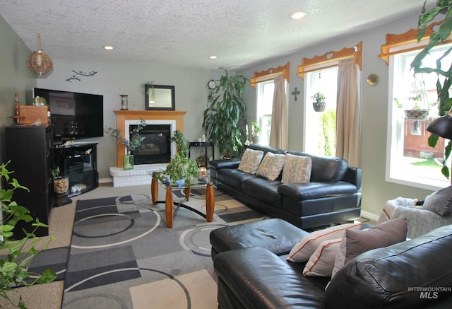 living room featuring recessed lighting, a textured ceiling, carpet, and a fireplace